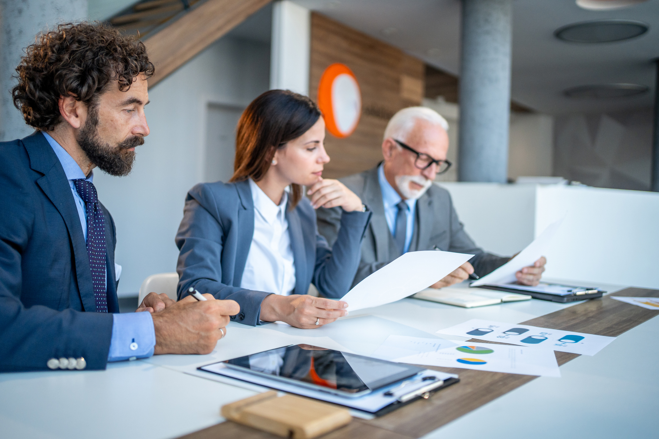 Group of persons reading documents at the office