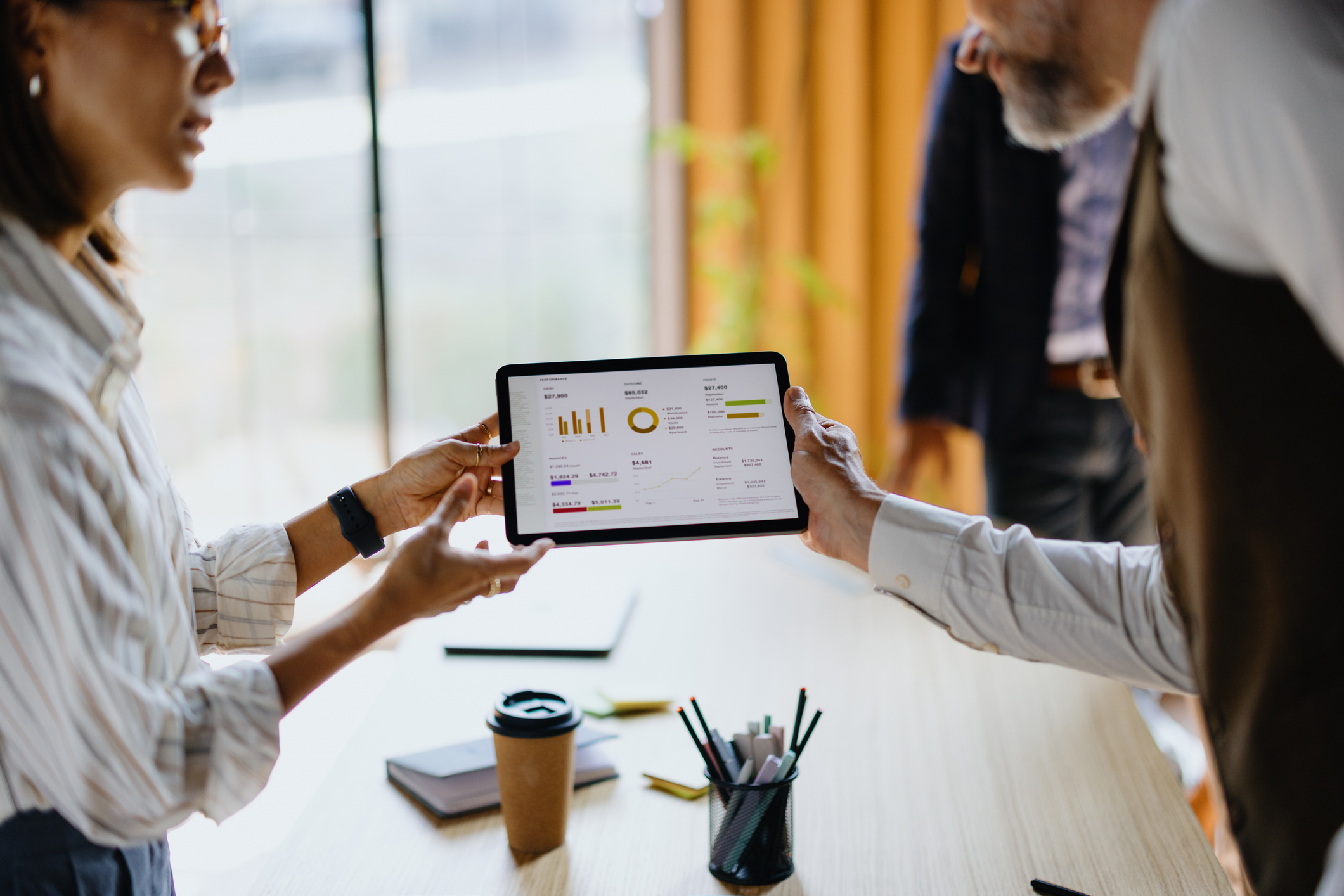 Person reading something in a tablet and showing data to a group