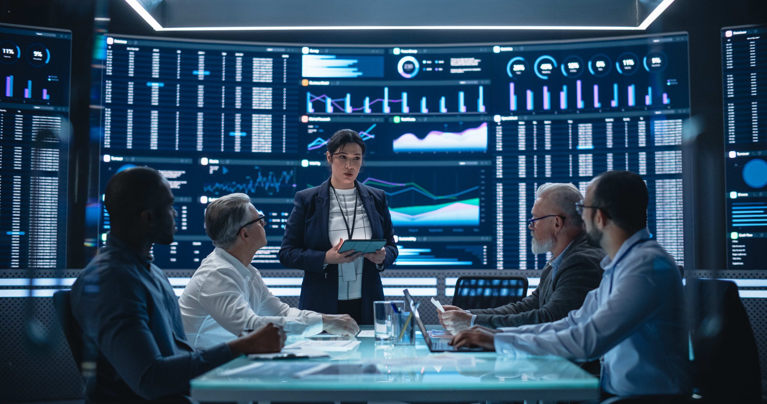 Executives in a meeting consulting metrics in a dashboard