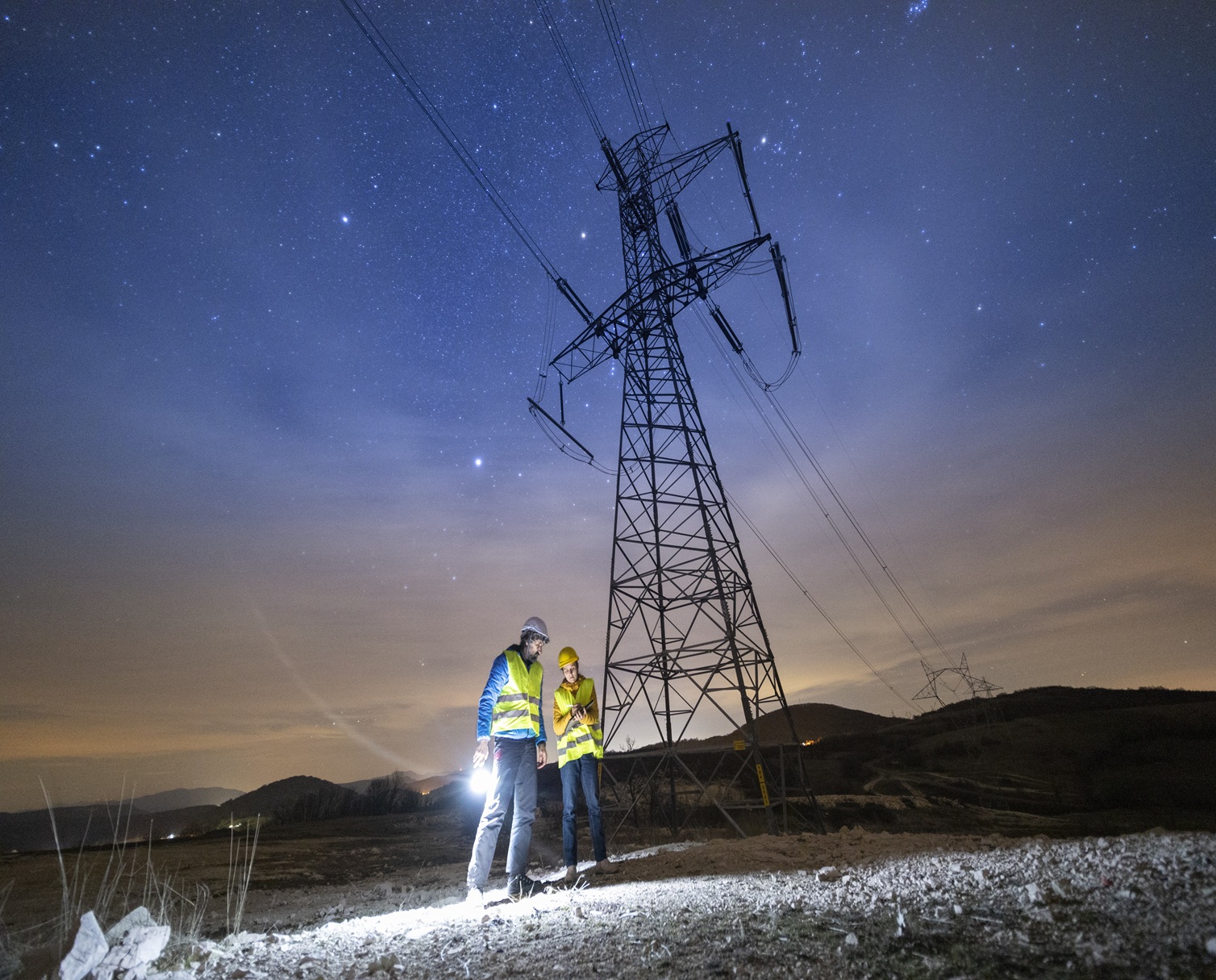 Utility field engineer inspecting power transmission infrastructure for resilient, adaptive and autonomous grid operations