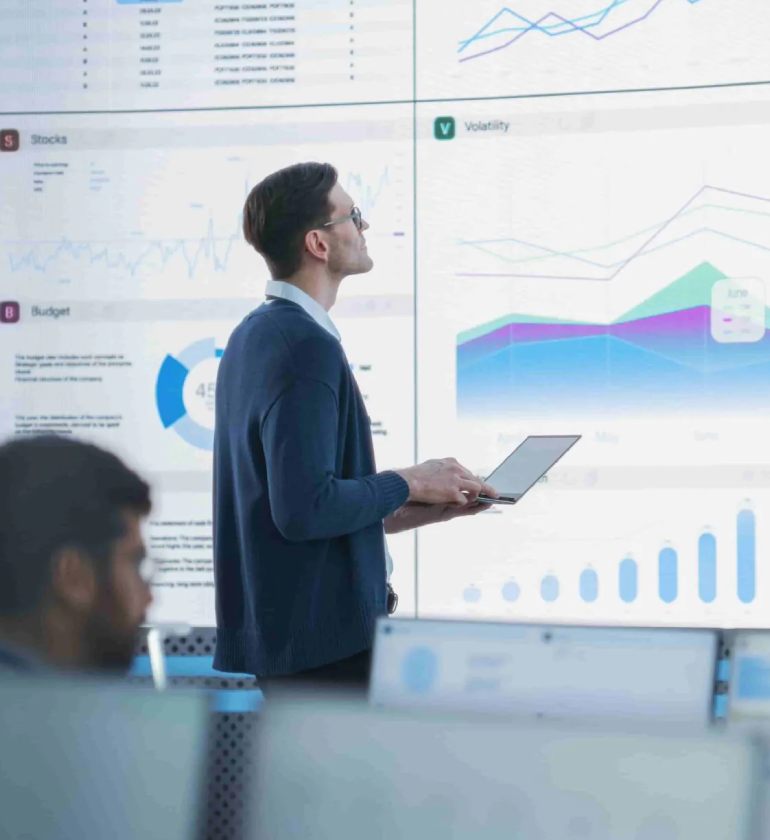 A business man analyzing a dashboard with a lapton on his hand