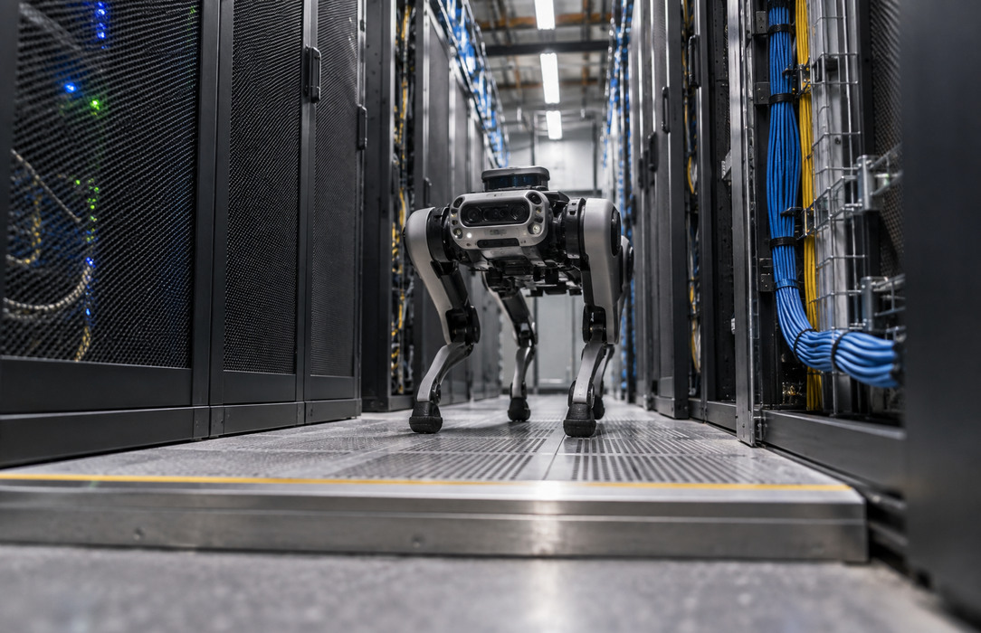 Autonomous inspection robot navigating a narrow data center aisle with dense server racks and a raised floor threshold.
