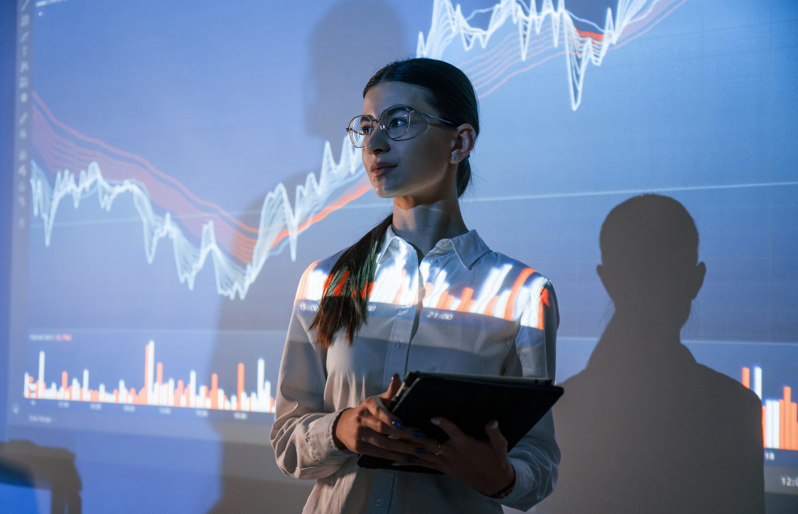 Energy market specialist reviewing live price and market trend data on a large screen to support fast trading and portfolio decisions.